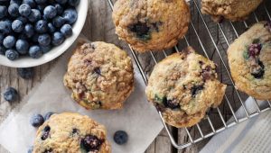 Blueberry muffins with berries and cooling rack.  