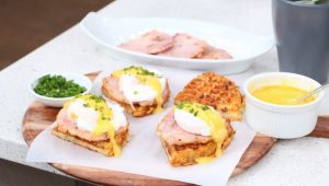 Eggs benedict on a waffled herb potato hash brown